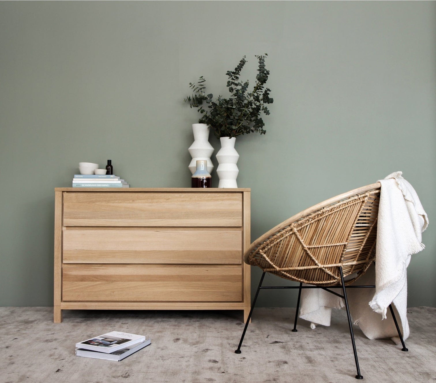 Wooden dresser, woven chair, and decorative vases.